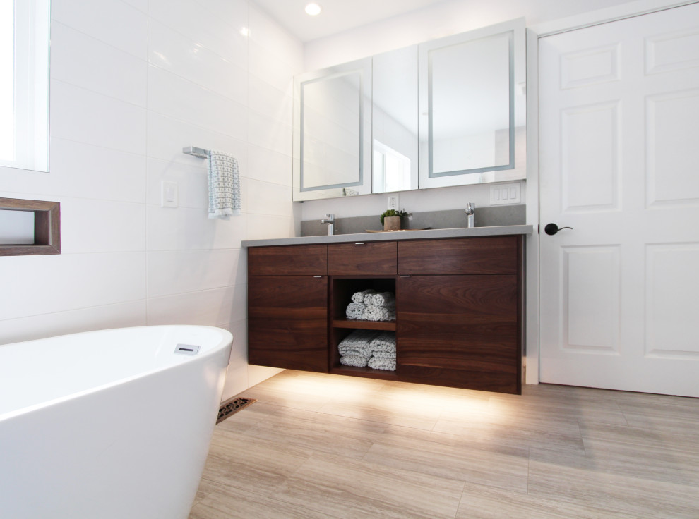Freestanding bathtub - large transitional master white tile and ceramic tile porcelain tile, gray floor and double-sink freestanding bathtub idea with flat-panel cabinets, dark wood cabinets, a one-piece toilet, white walls, an undermount sink, quartz countertops, gray countertops, a niche and a floating vanity