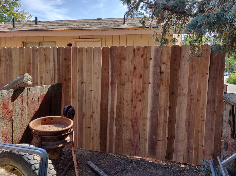 На фото: участок и сад в классическом стиле с перегородкой для приватности и с деревянным забором с