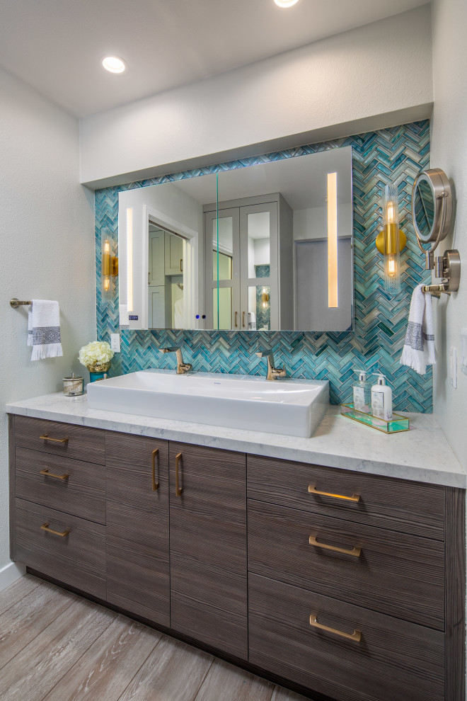 This is an example of a large transitional master wet room bathroom in San Diego with flat-panel cabinets, dark wood cabinets, a one-piece toilet, blue tile, white walls, a vessel sink, engineered quartz benchtops, green floor, a hinged shower door, white benchtops and medium hardwood floors.
