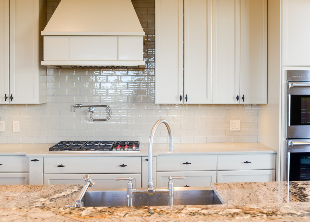 Large transitional medium tone wood floor eat-in kitchen photo in Calgary with recessed-panel cabinets, beige cabinets, beige backsplash, subway tile backsplash and an island