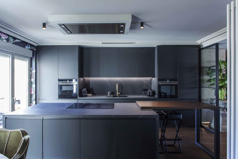 Inspiration för ett eklektiskt grå linjärt grått kök och matrum, med en integrerad diskho, släta luckor, grå skåp, marmorbänkskiva, grått stänkskydd, stänkskydd i marmor, integrerade vitvaror, mörkt trägolv, en köksö och brunt golv