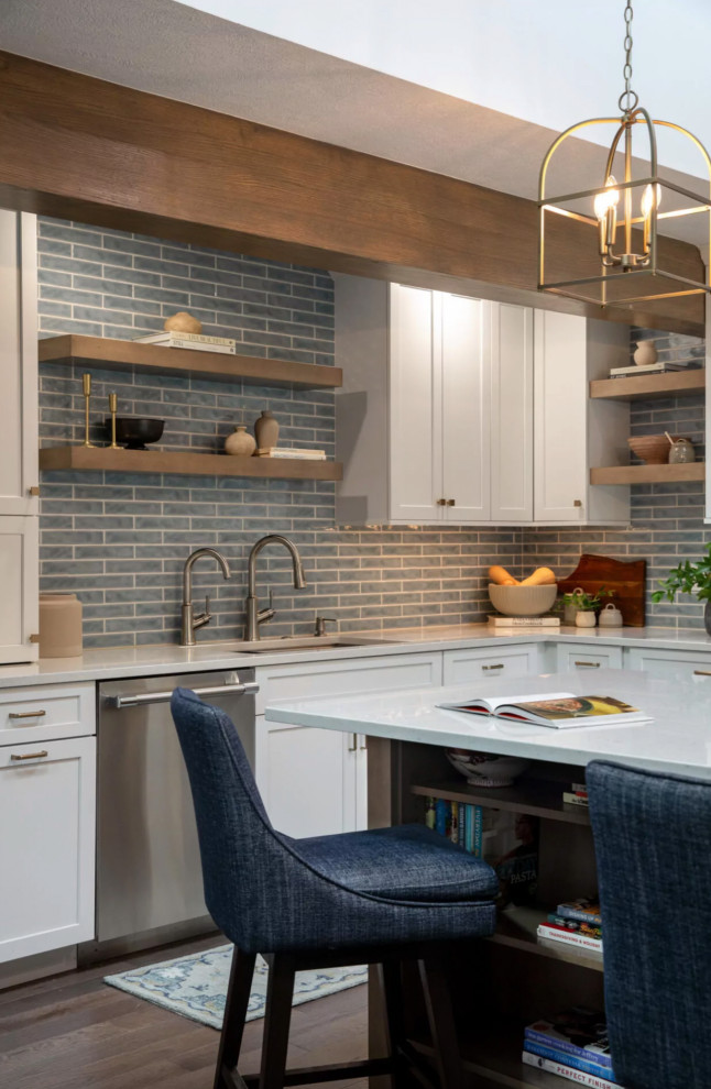 Large beach style l-shaped dark wood floor, brown floor and exposed beam eat-in kitchen photo with a farmhouse sink, recessed-panel cabinets, white cabinets, quartz countertops, blue backsplash, porcelain backsplash, stainless steel appliances, an island and white countertops