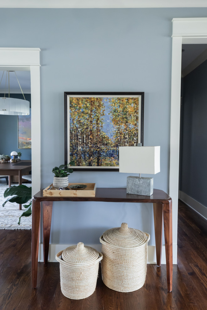 This is an example of an eclectic entryway in Chicago with blue walls, dark hardwood floors and brown floor.