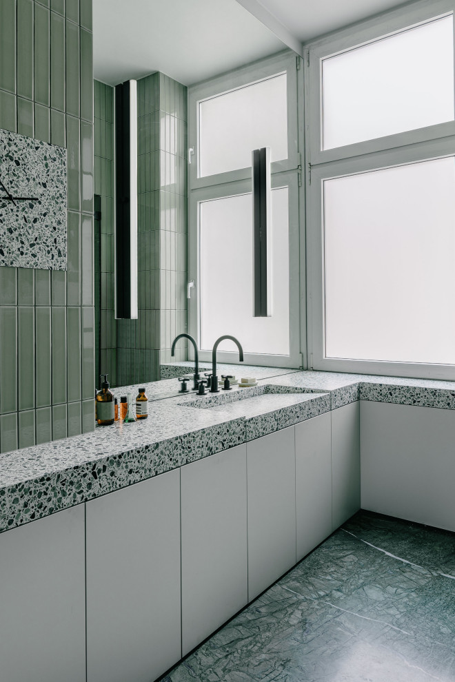 На фото: ванная комната в стиле модернизм с серыми фасадами, душем в нише, зеленой плиткой, удлиненной плиткой, мраморным полом, столешницей терраццо, зеленым полом, душем с распашными дверями, тумбой под одну раковину и встроенной тумбой с
