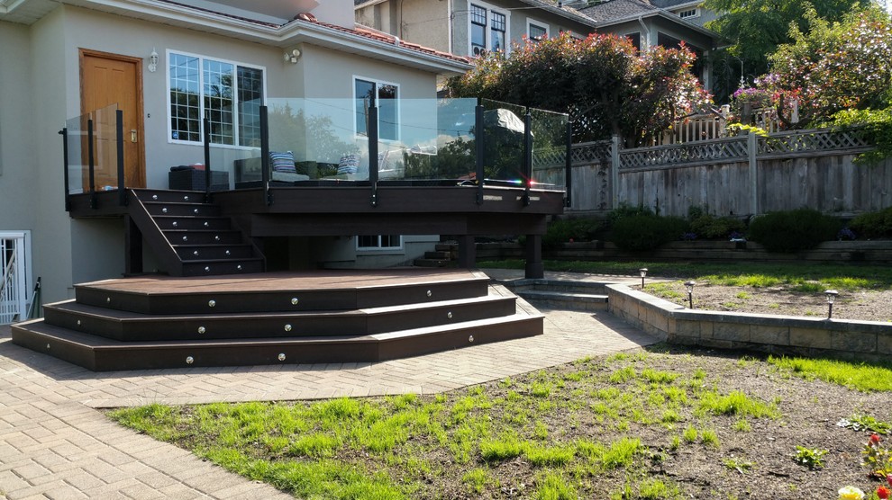 This is an example of a large modern backyard deck in Vancouver with no cover.