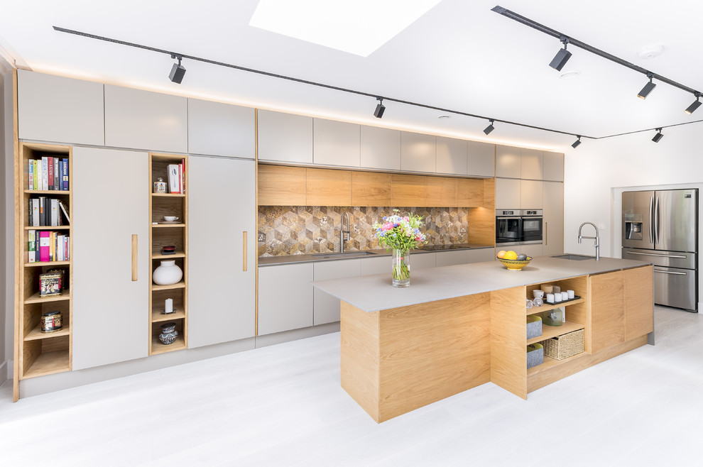 Inspiration for a large contemporary single-wall kitchen in London with flat-panel cabinets, grey cabinets, multi-coloured splashback, stainless steel appliances, with island, grey floor, grey benchtop and ceramic splashback.