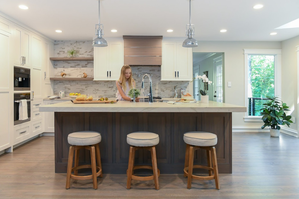 Inspiration for a mid-sized contemporary l-shaped kitchen pantry in DC Metro with a farmhouse sink, shaker cabinets, medium wood cabinets, quartzite benchtops, multi-coloured splashback, porcelain splashback, panelled appliances, medium hardwood floors, with island, brown floor and white benchtop.
