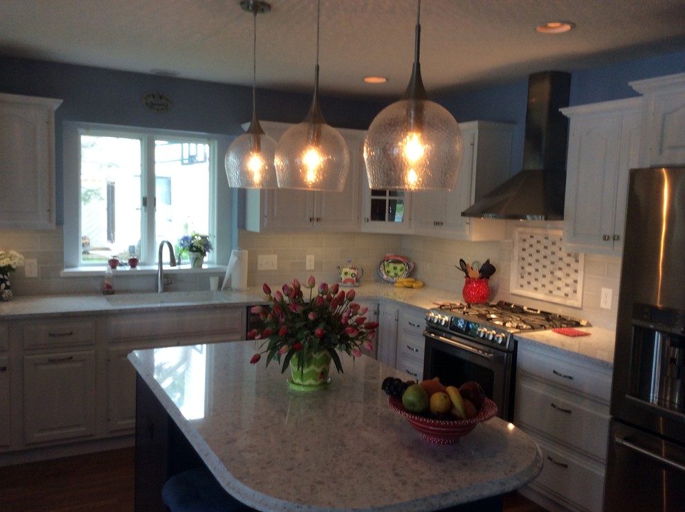 Enclosed kitchen - mid-sized transitional l-shaped dark wood floor enclosed kitchen idea with an undermount sink, raised-panel cabinets, white cabinets, quartz countertops, gray backsplash, mosaic tile backsplash, stainless steel appliances and an island