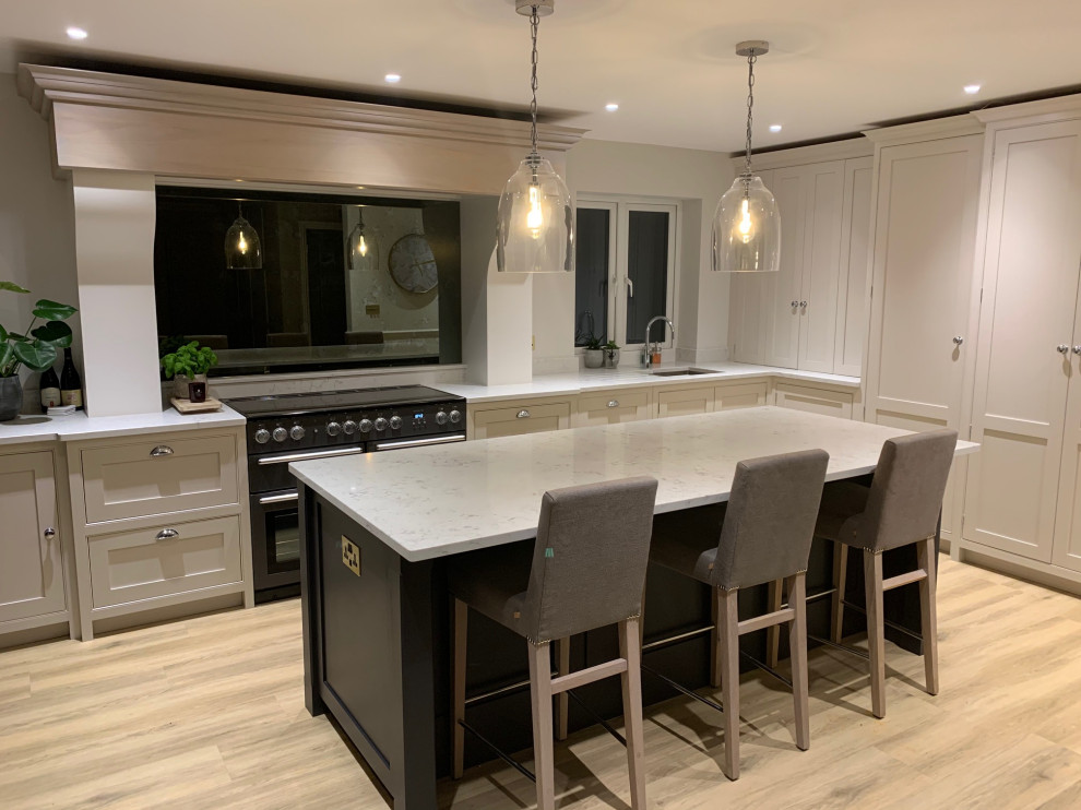 This is an example of a mid-sized contemporary l-shaped kitchen in Surrey with beaded inset cabinets, quartzite benchtops, mirror splashback, with island and white benchtop.