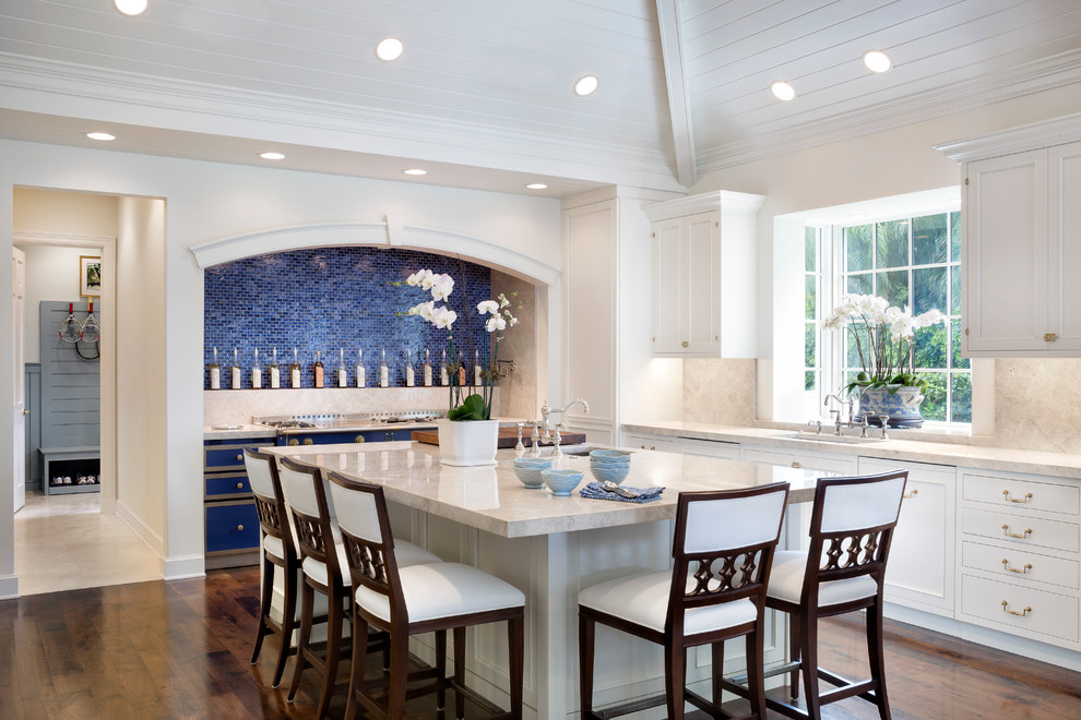 Inspiration for a beach style l-shaped kitchen with an undermount sink, recessed-panel cabinets, white cabinets, blue splashback, mosaic tile splashback, dark hardwood floors and with island.