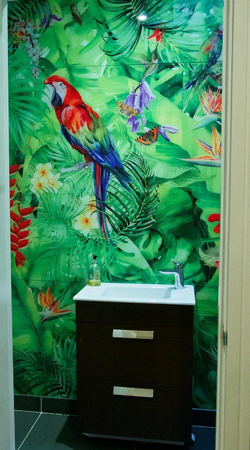 Small tropical 3/4 bathroom in London with brown cabinets, a wall-mount toilet, multi-coloured tile, glass sheet wall, multi-coloured walls, slate floors, a drop-in sink, grey floor, white benchtops, an enclosed toilet, a single vanity and a built-in vanity.