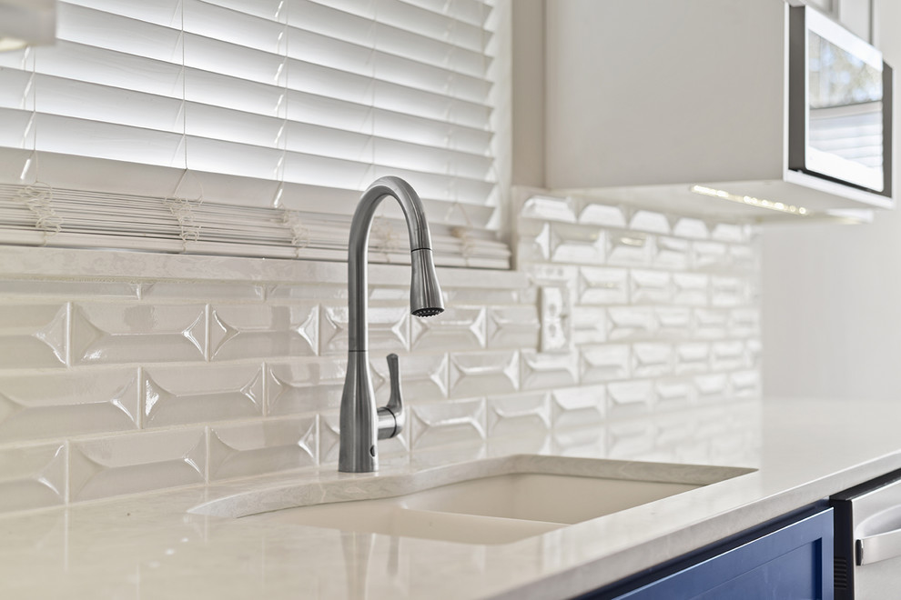 Inspiration for a large transitional l-shaped vinyl floor and brown floor open concept kitchen remodel in Jacksonville with an undermount sink, shaker cabinets, blue cabinets, quartzite countertops, white backsplash, ceramic backsplash, stainless steel appliances and a peninsula