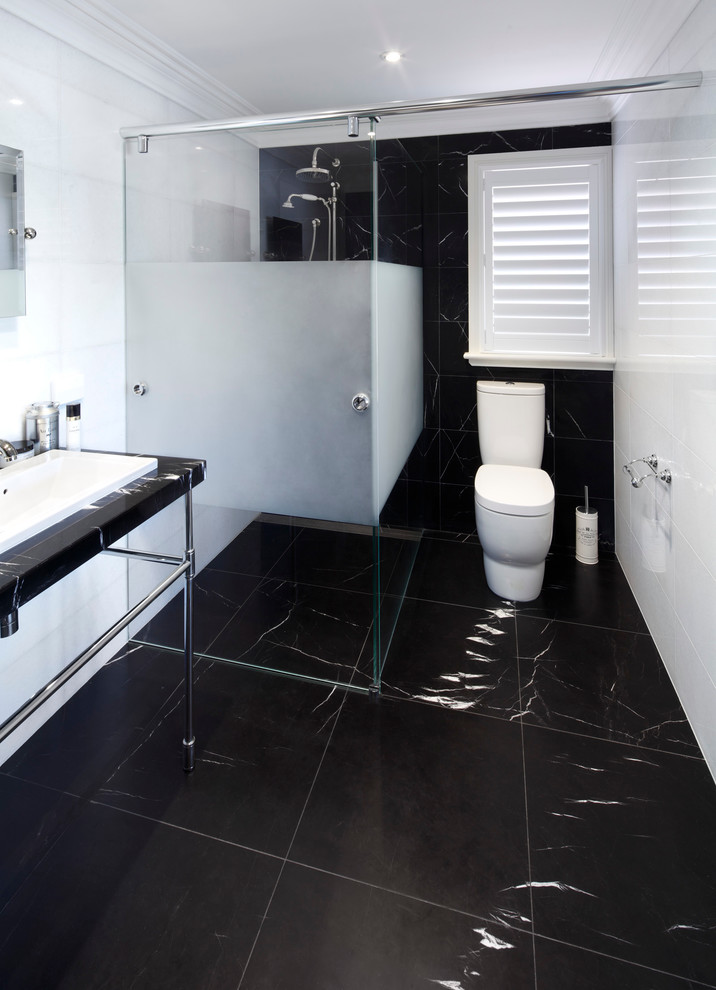 Design ideas for a large contemporary master wet room bathroom in Sydney with a freestanding tub, black tile, black and white tile, white tile, marble floors, a console sink, black floor and a hinged shower door.