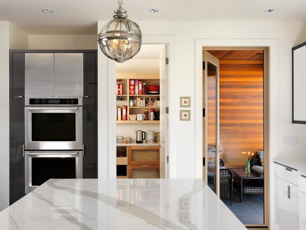 Inspiration for a transitional eat-in kitchen remodel with an undermount sink, flat-panel cabinets, white cabinets, quartz countertops, stainless steel appliances and an island