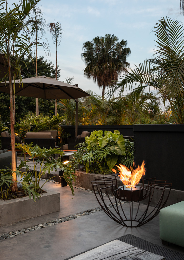 Design ideas for a large tropical rooftop and rooftop deck in Miami with a fire feature.