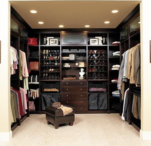 This is an example of a large traditional gender-neutral walk-in wardrobe in Atlanta with open cabinets, dark wood cabinets, ceramic floors and beige floor.