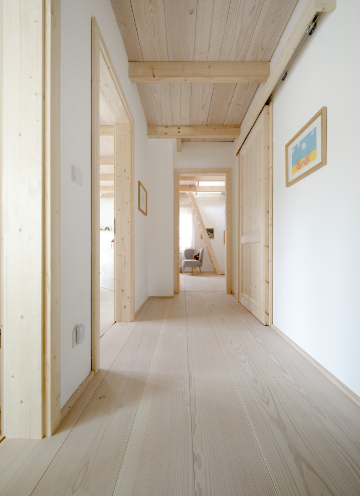 Mittelgroßer Nordischer Schmaler Flur mit weißer Wandfarbe, hellem Holzboden, weißem Boden, Holzdielendecke und Tapetenwänden in München