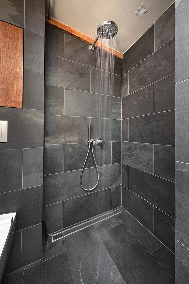 Idéer för att renovera ett litet funkis badrum med dusch, med skåp i mörkt trä, en kantlös dusch, en vägghängd toalettstol, grå kakel, skifferkakel, grå väggar, skiffergolv och ett fristående handfat