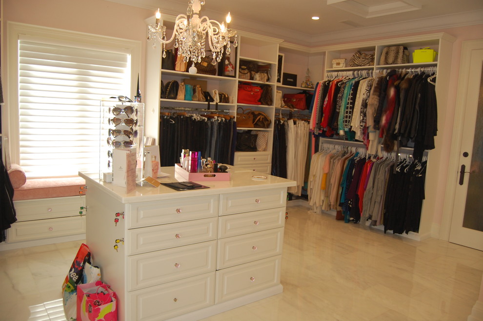 Expansive traditional women's dressing room in Toronto with raised-panel cabinets, white cabinets and travertine floors.