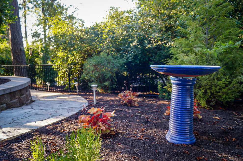 Photo of a mid-sized rustic partial sun backyard concrete paver retaining wall landscape.