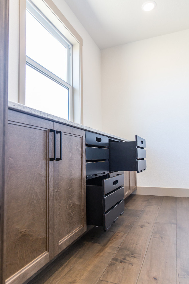 Inspiration for a large transitional u-shaped medium tone wood floor and brown floor kitchen pantry remodel with a farmhouse sink, shaker cabinets, medium tone wood cabinets, quartz countertops, beige backsplash, ceramic backsplash, black appliances, an island and multicolored countertops