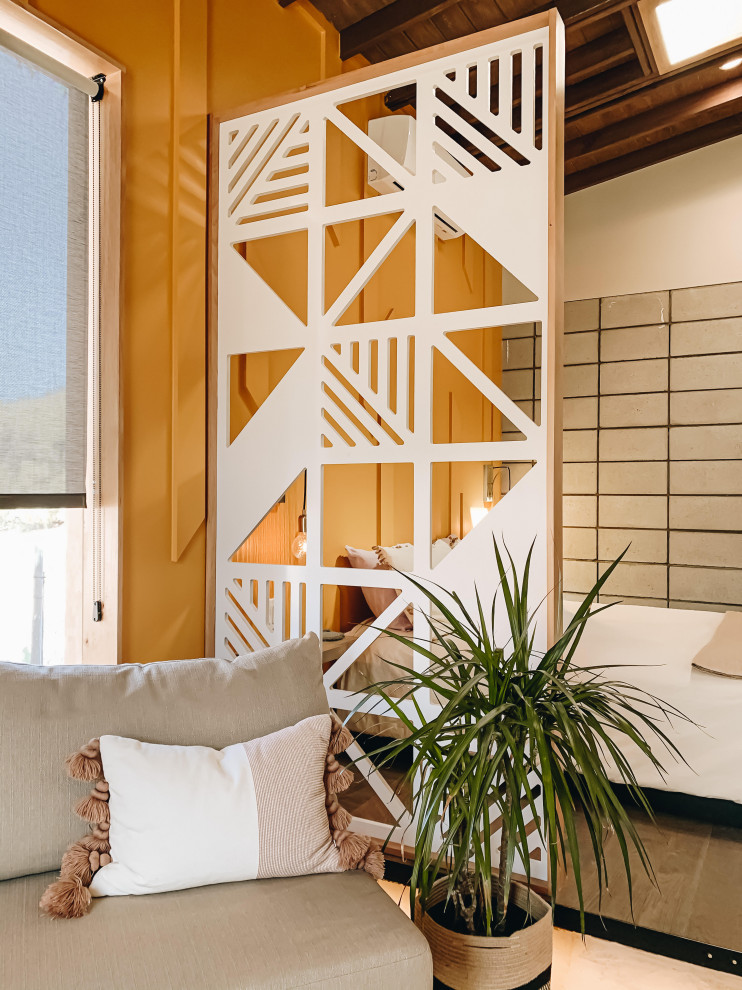 ロサンゼルスにある小さなモダンスタイルのおしゃれな客用寝室 (黄色い壁、コンクリートの床、白い床、表し梁、パネル壁) のインテリア