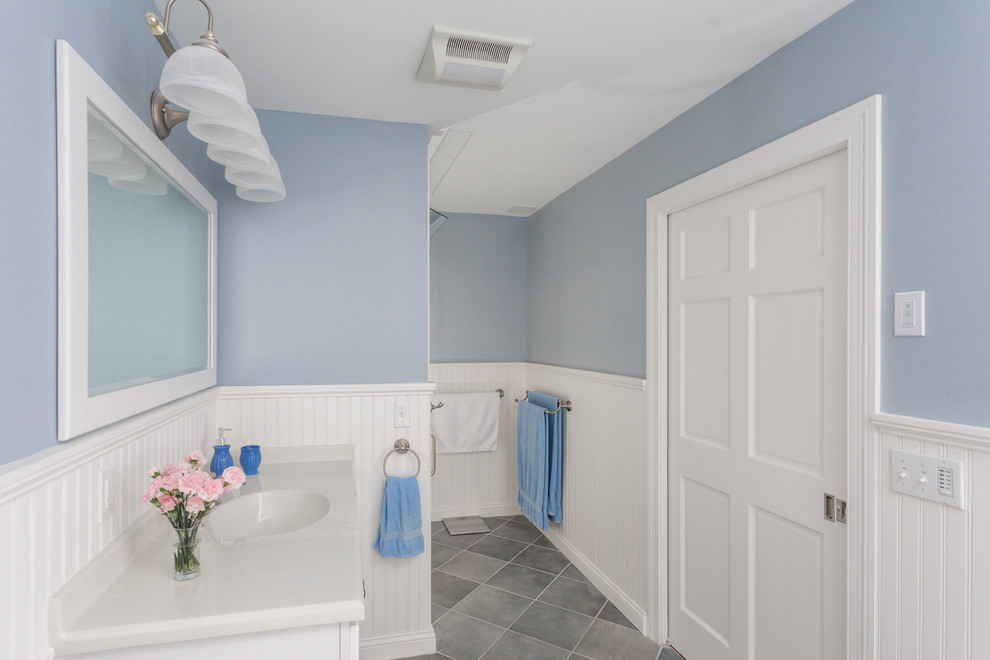 Small traditional 3/4 bathroom in Boston with shaker cabinets, white cabinets, a two-piece toilet, gray tile, ceramic tile, blue walls, ceramic floors, an integrated sink, laminate benchtops, a drop-in tub and an alcove shower.