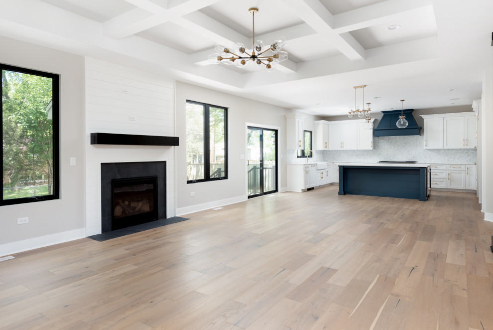 This is an example of a large country open concept family room in Chicago with grey walls, light hardwood floors, a standard fireplace, a tile fireplace surround, beige floor, coffered and planked wall panelling.