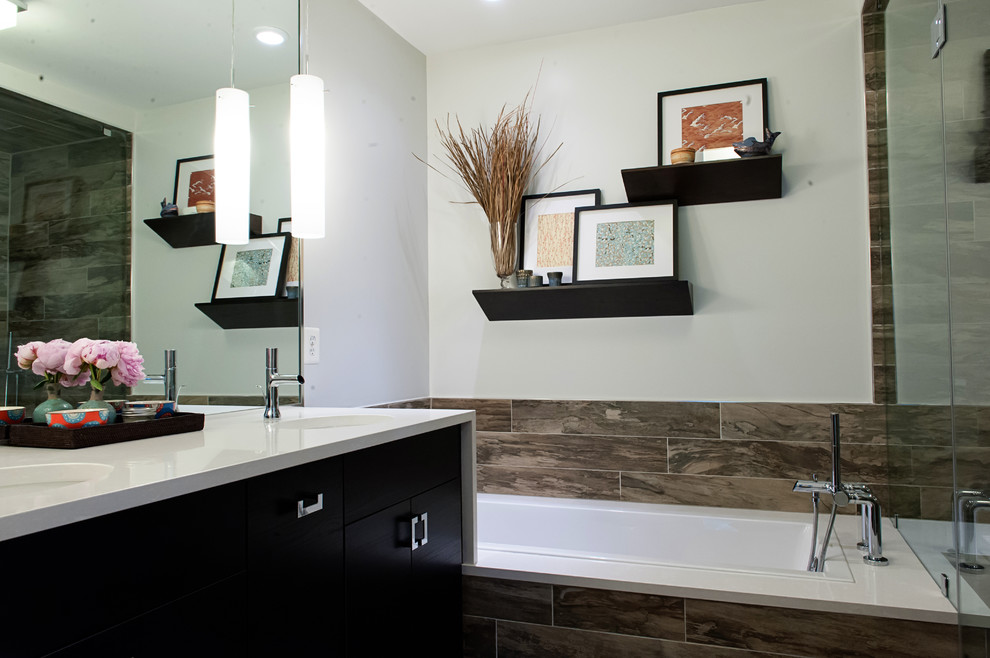 Photo of a small transitional master bathroom in DC Metro with flat-panel cabinets, dark wood cabinets, engineered quartz benchtops, a drop-in tub, a corner shower, gray tile, porcelain tile, grey walls, porcelain floors, a drop-in sink and white benchtops.