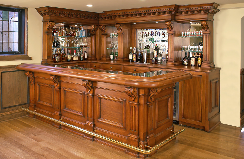 This is an example of a mid-sized single-wall seated home bar in New York with raised-panel cabinets, wood benchtops, no sink, medium wood cabinets, grey splashback, mirror splashback, laminate floors, yellow floor and yellow benchtop.