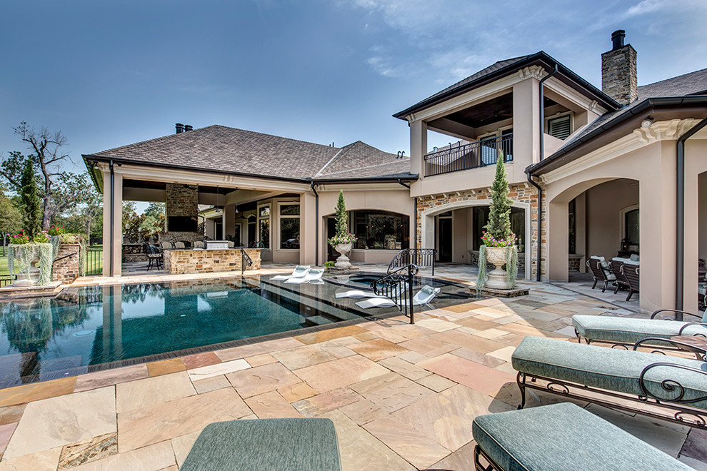 Inspiration for an expansive traditional backyard rectangular infinity pool in Houston with a hot tub and tile.