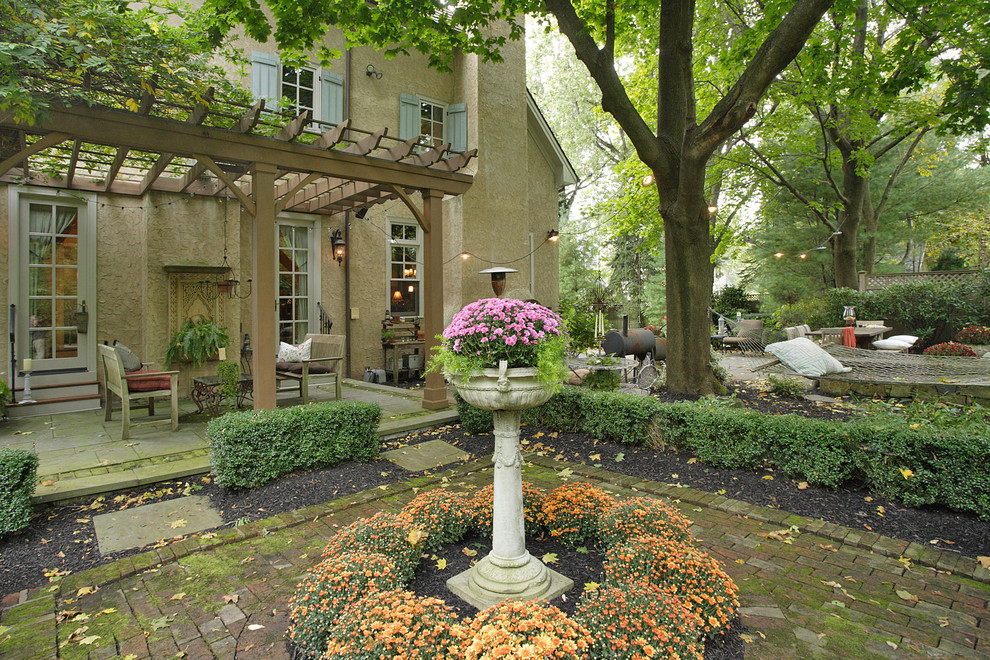 Photo of a large mediterranean backyard patio in New York with an outdoor kitchen, natural stone pavers and a pergola.