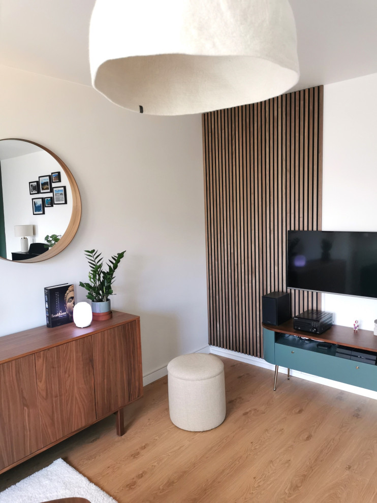Стильный дизайн: большая изолированная гостиная комната в современном стиле с зелеными стенами, паркетным полом среднего тона, коричневым полом и панелями на стенах - последний тренд