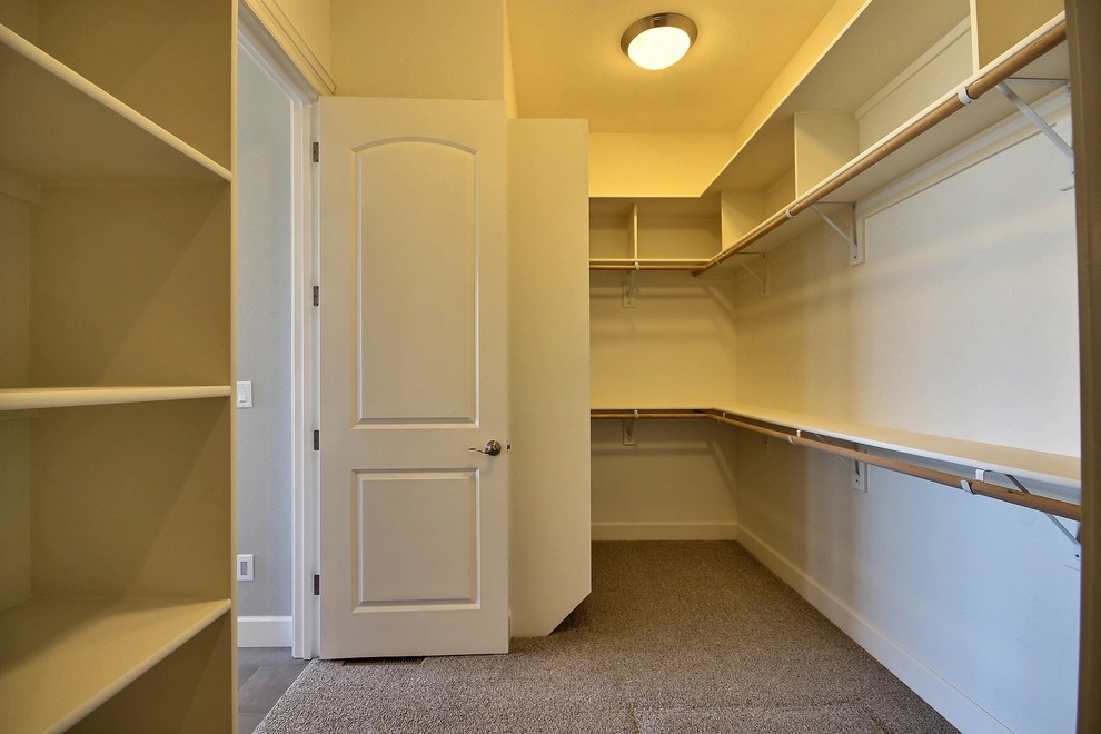 Large arts and crafts gender-neutral walk-in wardrobe in Portland with open cabinets, white cabinets and carpet.
