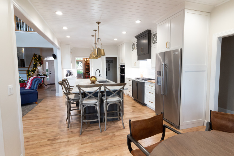 Example of a large l-shaped eat-in kitchen design with shaker cabinets, white cabinets, granite countertops, an island and white countertops