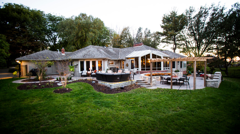 This is an example of a transitional backyard stone water fountain landscape in Omaha.