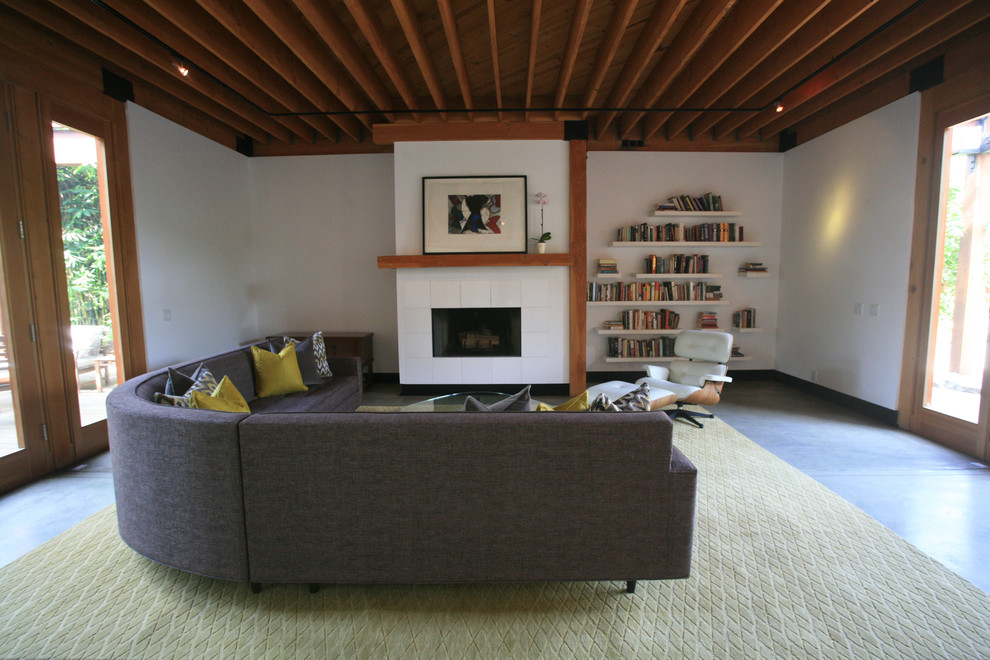 Design ideas for a large midcentury formal open concept living room in Los Angeles with yellow walls, concrete floors, a standard fireplace, a tile fireplace surround, no tv and grey floor.