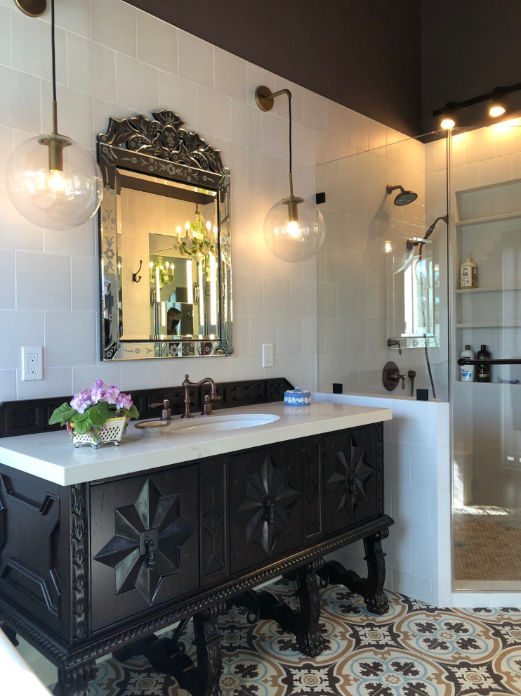 Photo of a mid-sized eclectic master bathroom in San Diego with furniture-like cabinets, dark wood cabinets, a freestanding tub, a corner shower, white tile, porcelain tile, brown walls, cement tiles, an undermount sink, engineered quartz benchtops, multi-coloured floor, a hinged shower door, beige benchtops, a niche, a single vanity and a freestanding vanity.