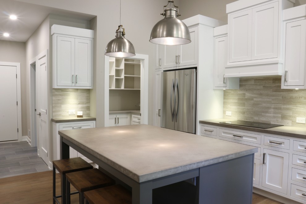 Example of a large transitional l-shaped dark wood floor open concept kitchen design in Grand Rapids with an undermount sink, shaker cabinets, white cabinets, quartz countertops, beige backsplash, porcelain backsplash, stainless steel appliances and an island