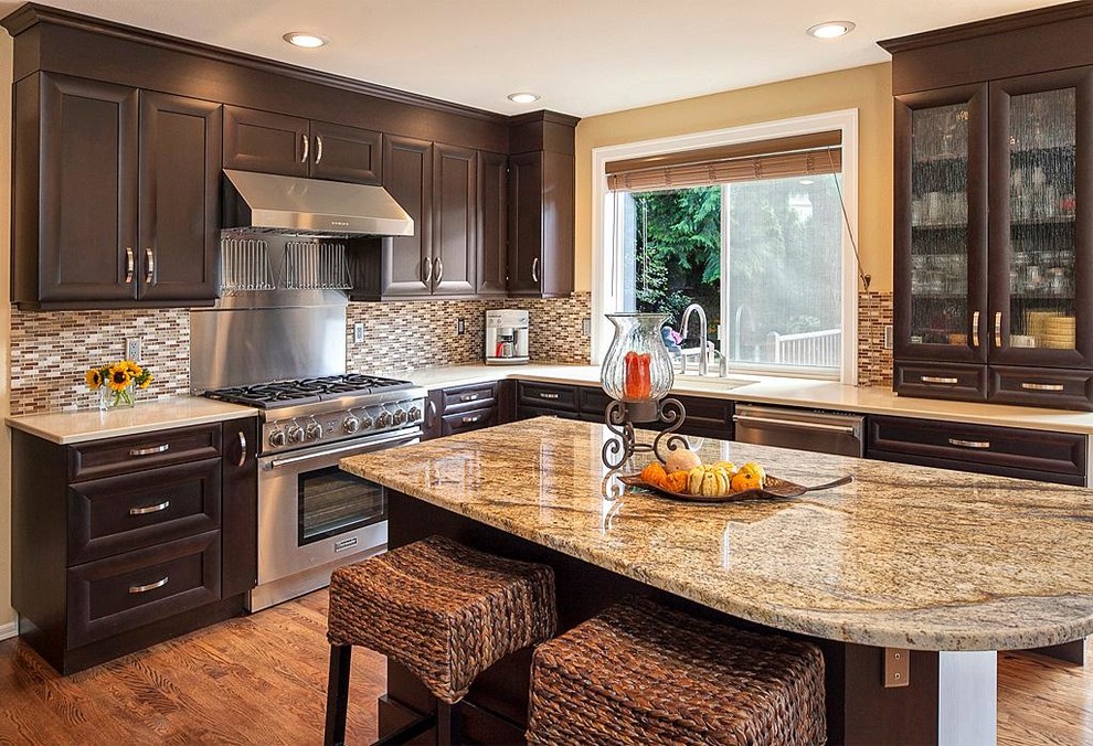 Example of a large transitional u-shaped medium tone wood floor eat-in kitchen design in Seattle with a drop-in sink, recessed-panel cabinets, dark wood cabinets, beige backsplash, stainless steel appliances, granite countertops, matchstick tile backsplash, beige walls and an island