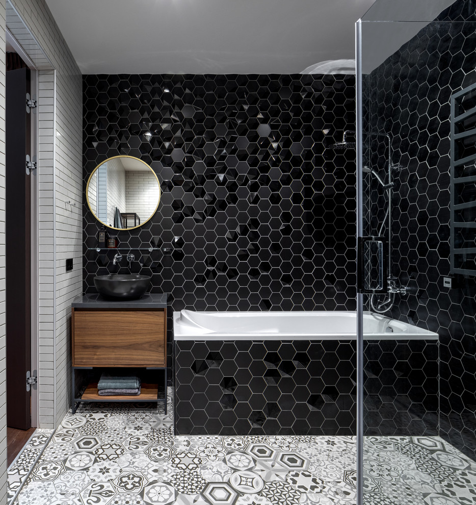 This is an example of a large contemporary master bathroom in Moscow with flat-panel cabinets, ceramic tile, ceramic floors, solid surface benchtops, grey floor, grey benchtops, a corner tub, black tile, a vessel sink and medium wood cabinets.