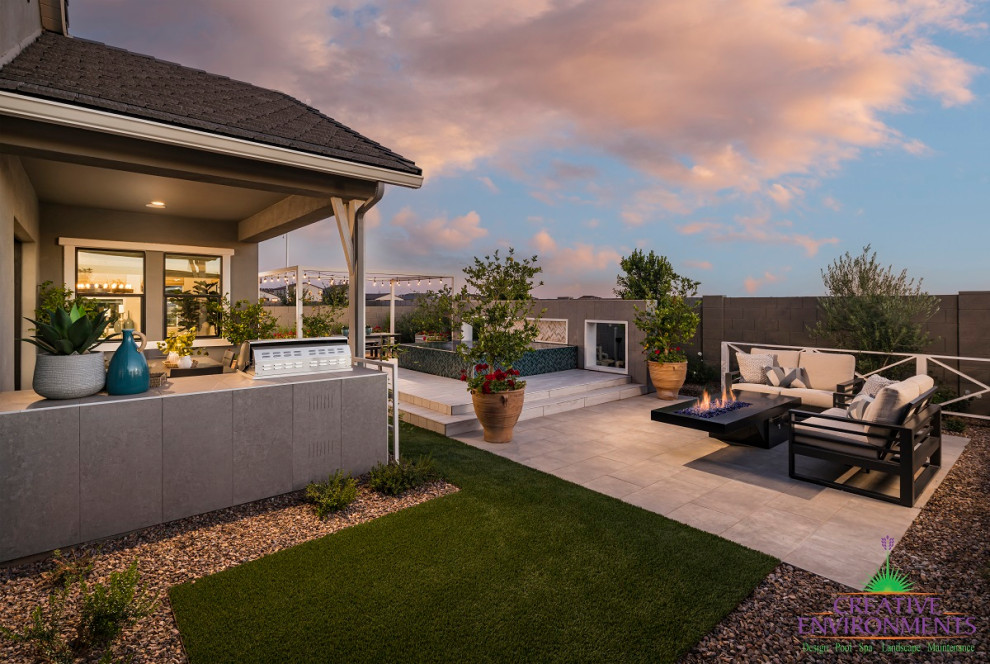 Immagine di un grande patio o portico minimalista dietro casa con graniglia di granito e un parasole