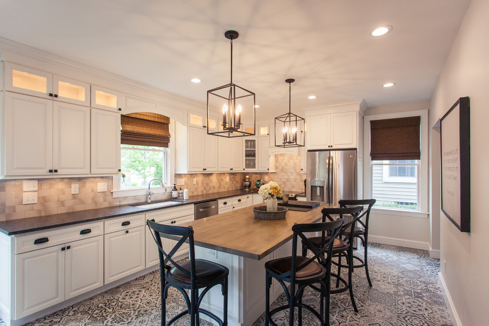 This is an example of a large country l-shaped separate kitchen in Cincinnati with a single-bowl sink, recessed-panel cabinets, white cabinets, granite benchtops, beige splashback, subway tile splashback, stainless steel appliances, porcelain floors, with island and multi-coloured floor.