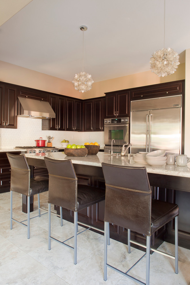 Kitchen - transitional kitchen idea in Orange County with raised-panel cabinets, dark wood cabinets, white backsplash and stainless steel appliances
