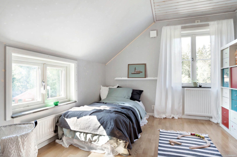 Small scandinavian kids' bedroom in Stockholm with grey walls, light hardwood floors and beige floor for kids 4-10 years old and boys.