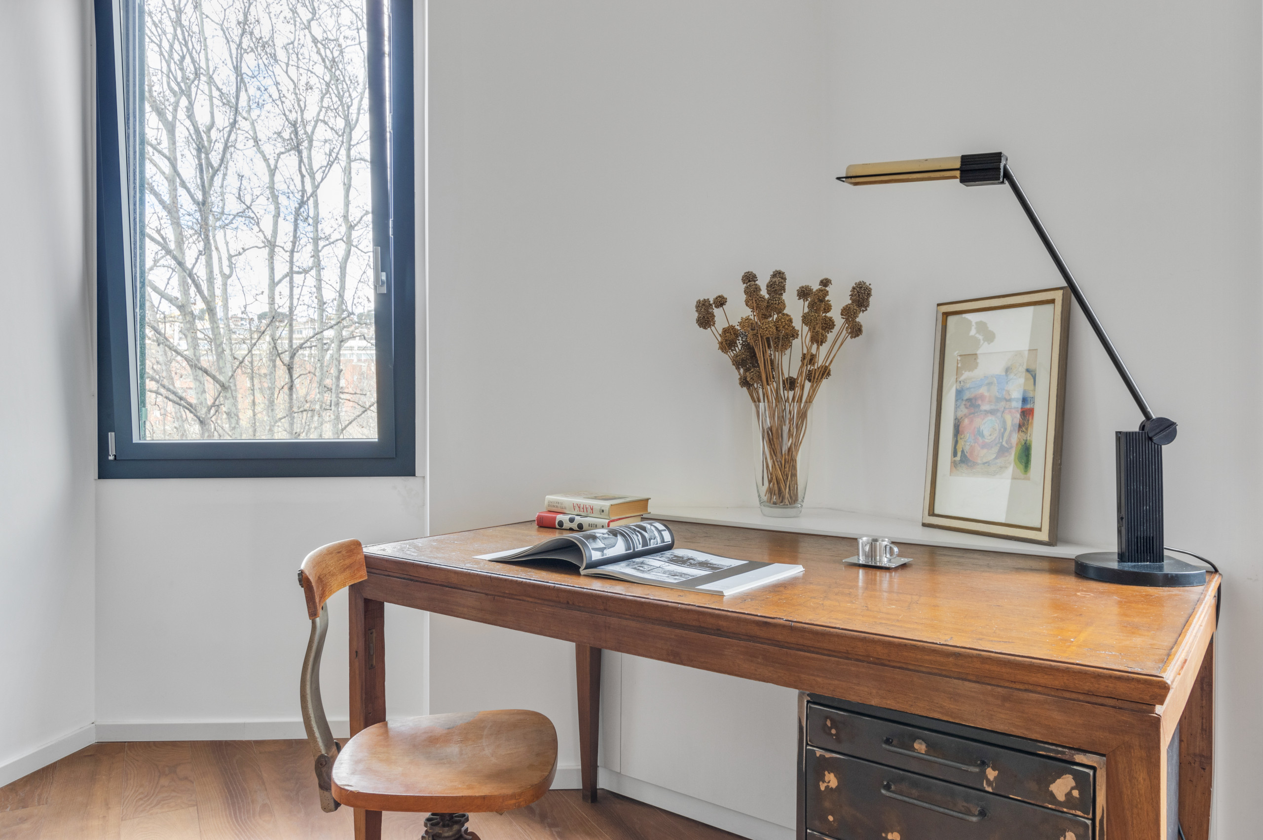 Home office - huge modern freestanding desk dark wood floor home office idea in Rome with white walls