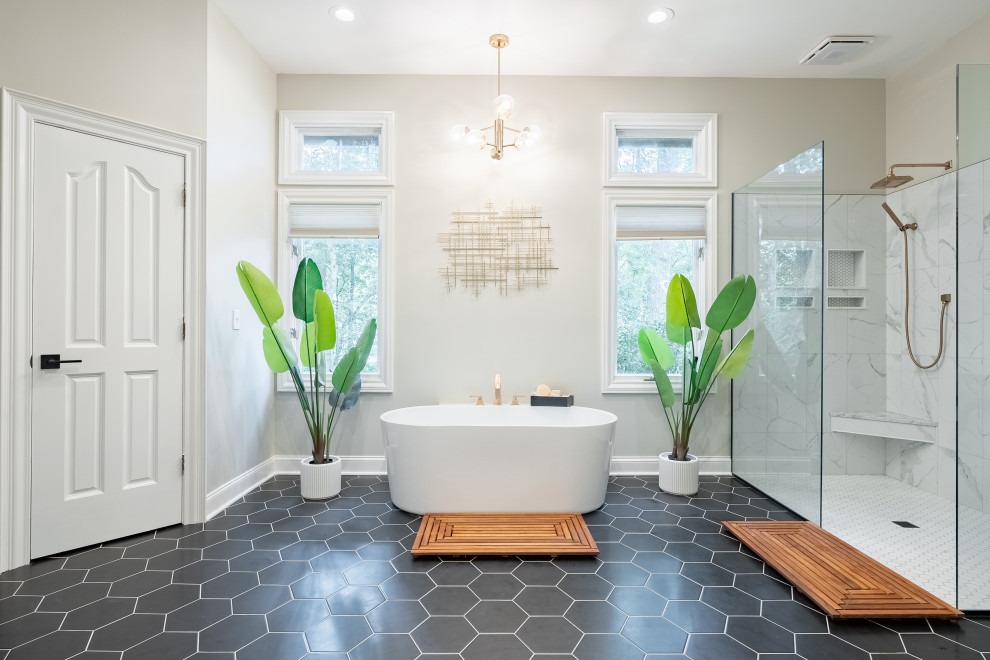 This is an example of an expansive traditional ensuite bathroom in Columbus with a freestanding bath, a built-in shower, grey walls, black floors, an open shower, an enclosed toilet and a built in vanity unit.