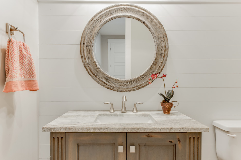 Small transitional powder room in Salt Lake City with recessed-panel cabinets, a two-piece toilet, multi-coloured tile, porcelain tile, beige walls, porcelain floors, an undermount sink, granite benchtops and medium wood cabinets.