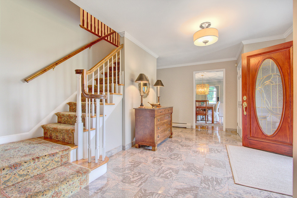 Mid-sized transitional marble floor foyer photo in New York with beige walls and a medium wood front door