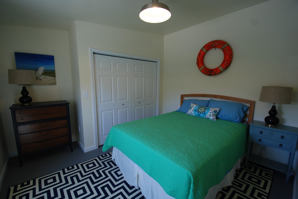 This is an example of a mid-sized beach style loft-style bedroom in Providence with white walls and concrete floors.